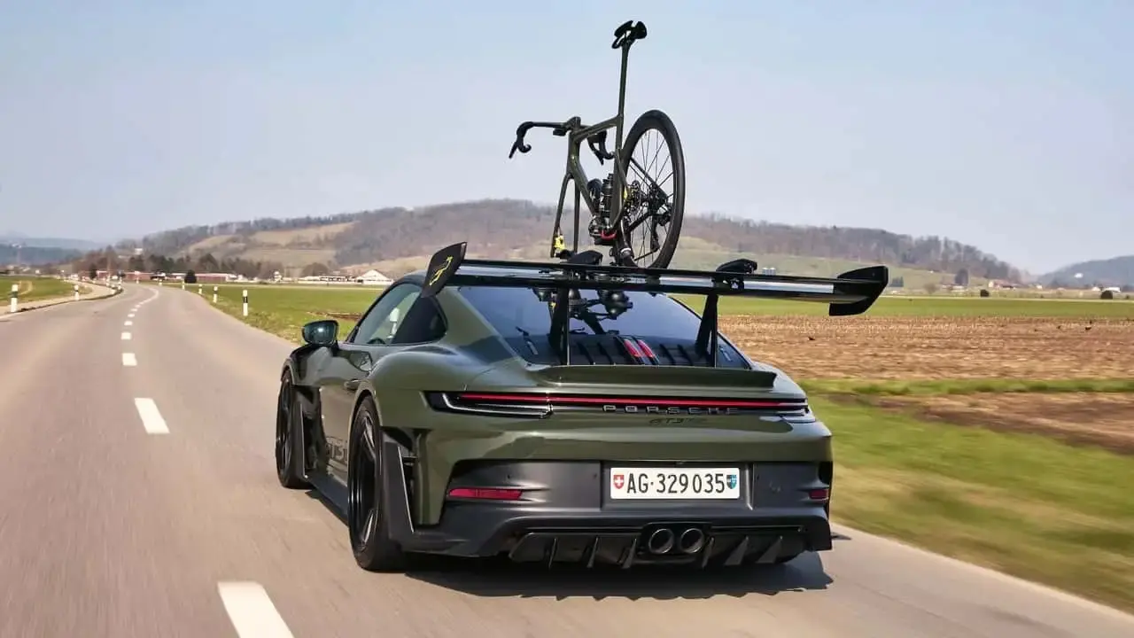 پورشه 911 GT3 RS مشکی زیتونی در کنار دوچرخه هماهنگ سفارشی